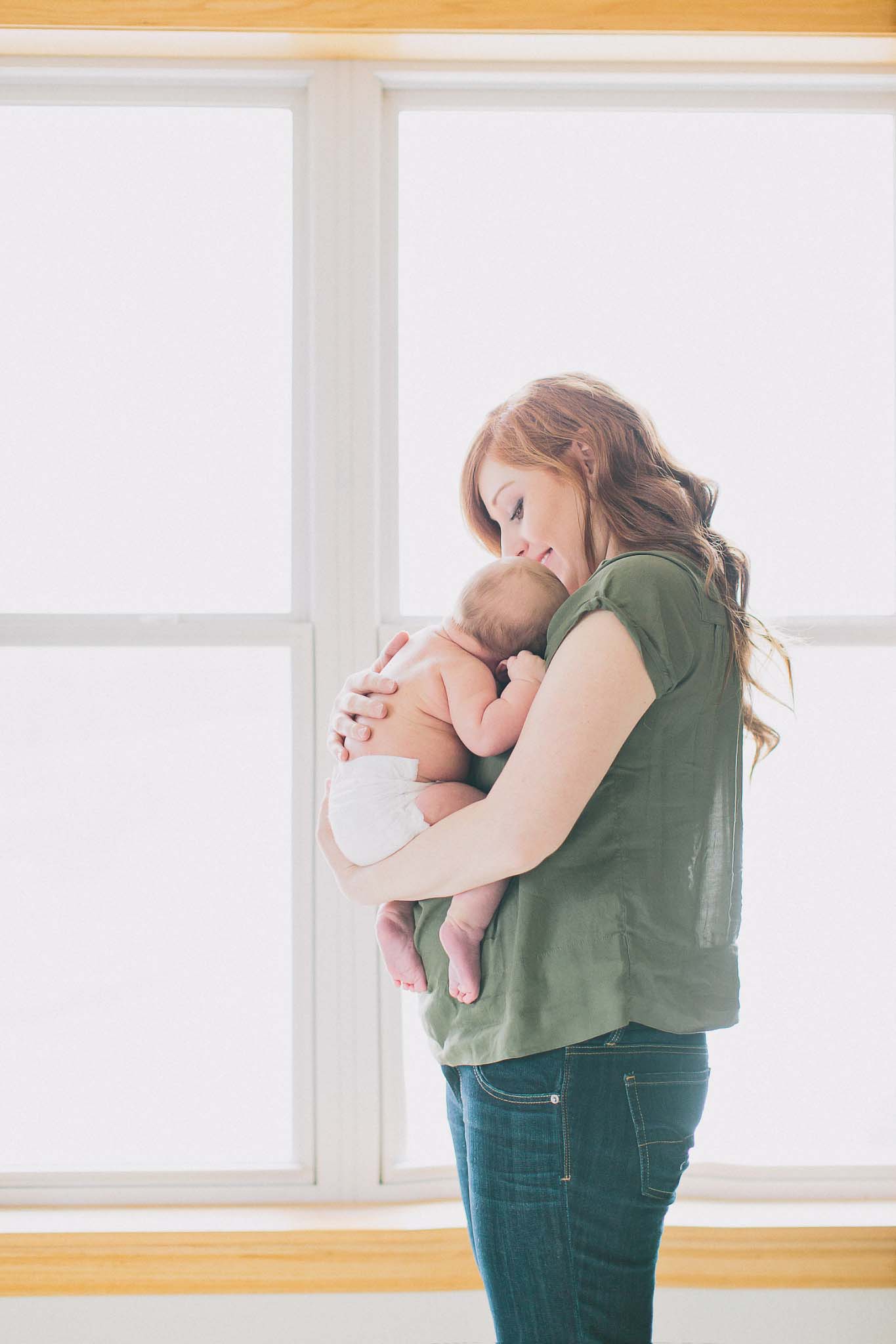gorgeous mom with baby in window light photo