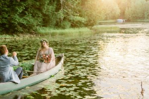 Bride and groom in canoe on lake in northern wisconsin